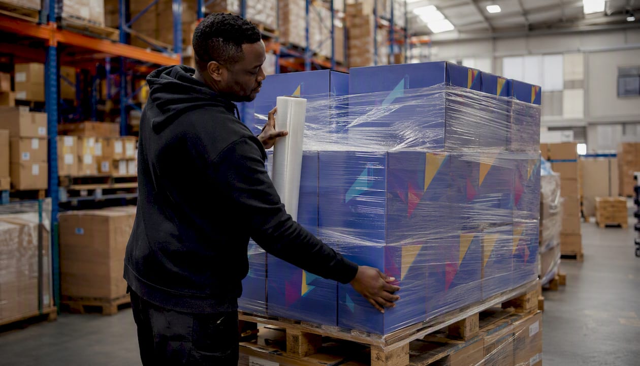 Worker loading promotional shipment in shipping bay