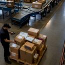 Worker scanning packages in logistics warehouse