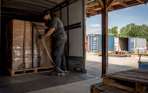 Truck driver securing cargo inside trailer