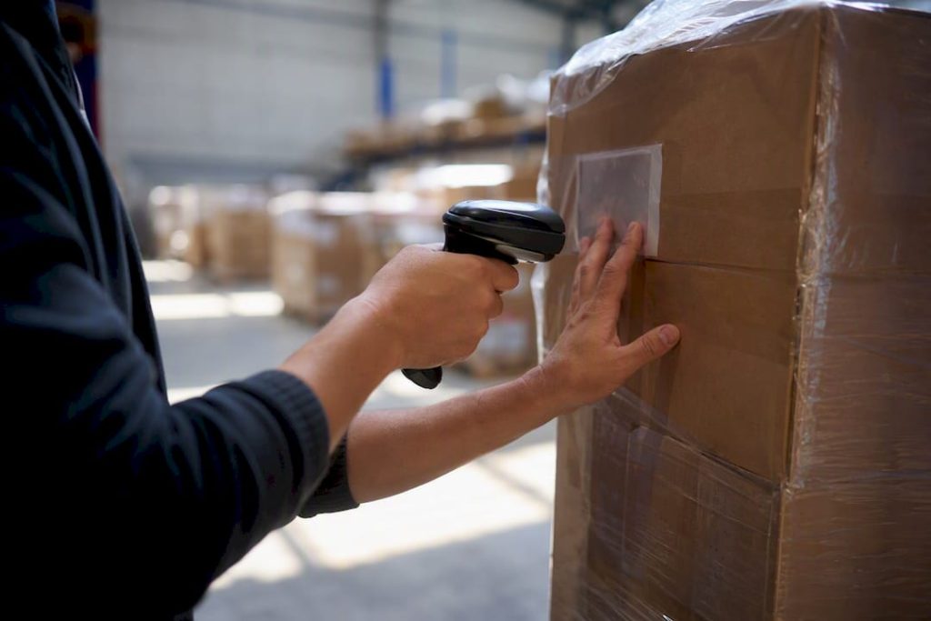 Hands scanning shipping label in warehouse