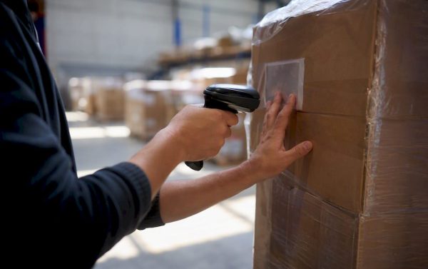 Hands scanning shipping label in warehouse