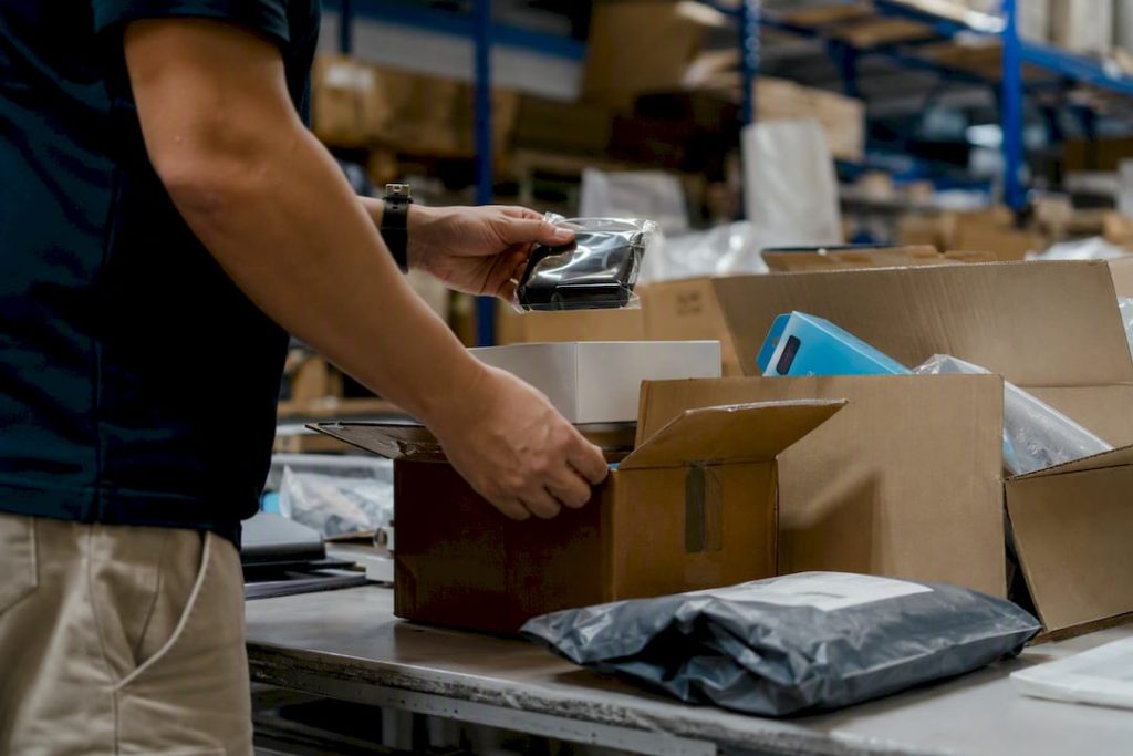Hands sorting packages in returns area