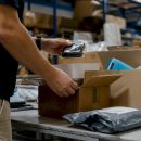 Hands sorting packages in returns area
