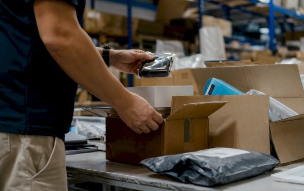 Hands sorting packages in returns area