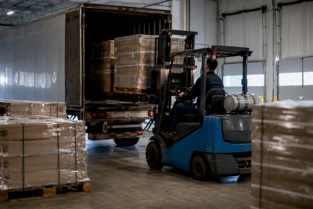 Forklift loading pallets into truck trailer