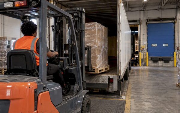 Forklift unloading freight at a receiving dock