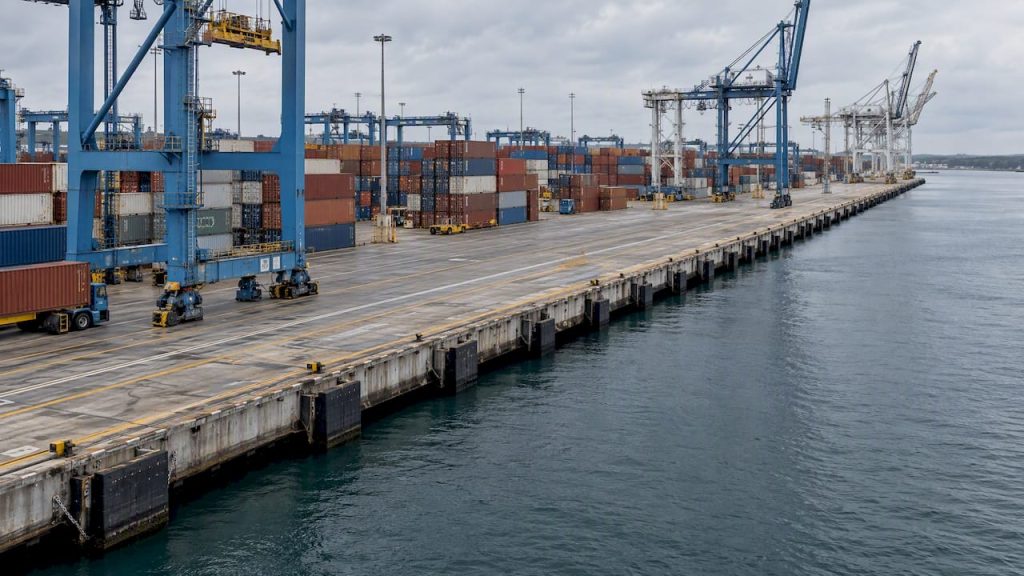 Container stacks beside an empty ship berth